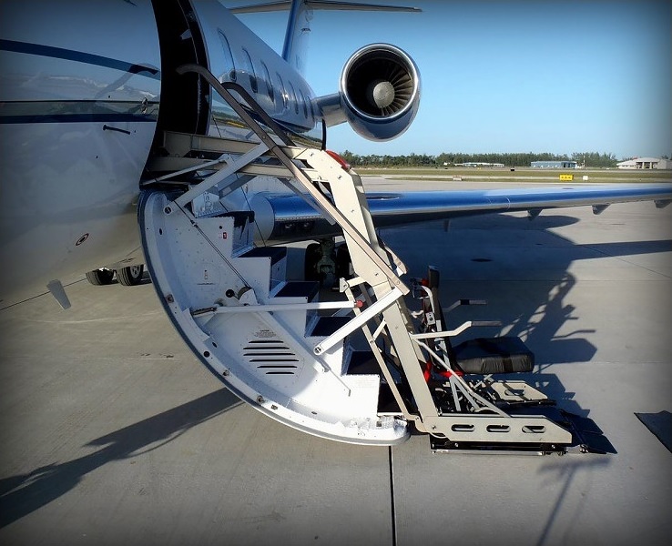 Wheelchair lift positioned alongside a private jet for boarding in Naples, Florida